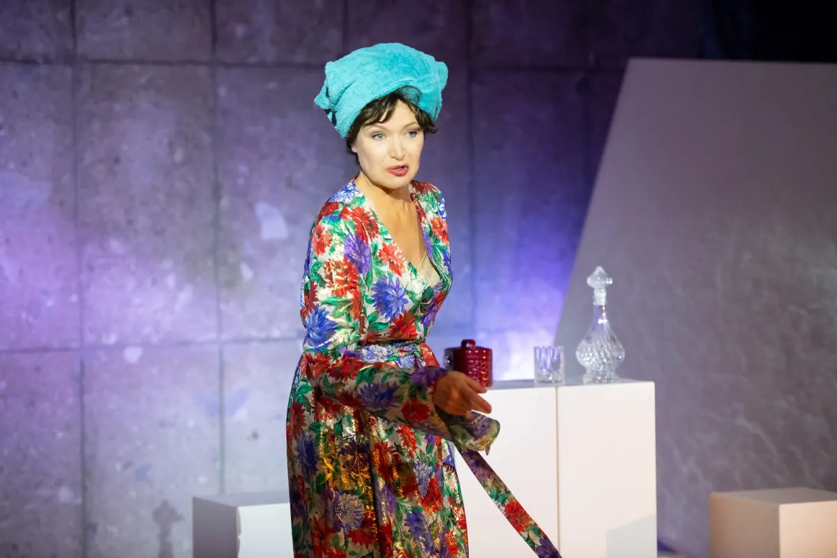 Edda Petri in einem farbenfrohen Kleid auf der Bühne